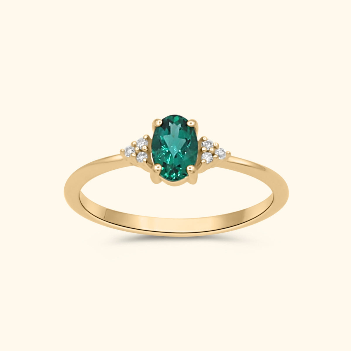 9 karaat gouden ring met een ovale lab grown smaragd en diamanten aan weerszijden.
