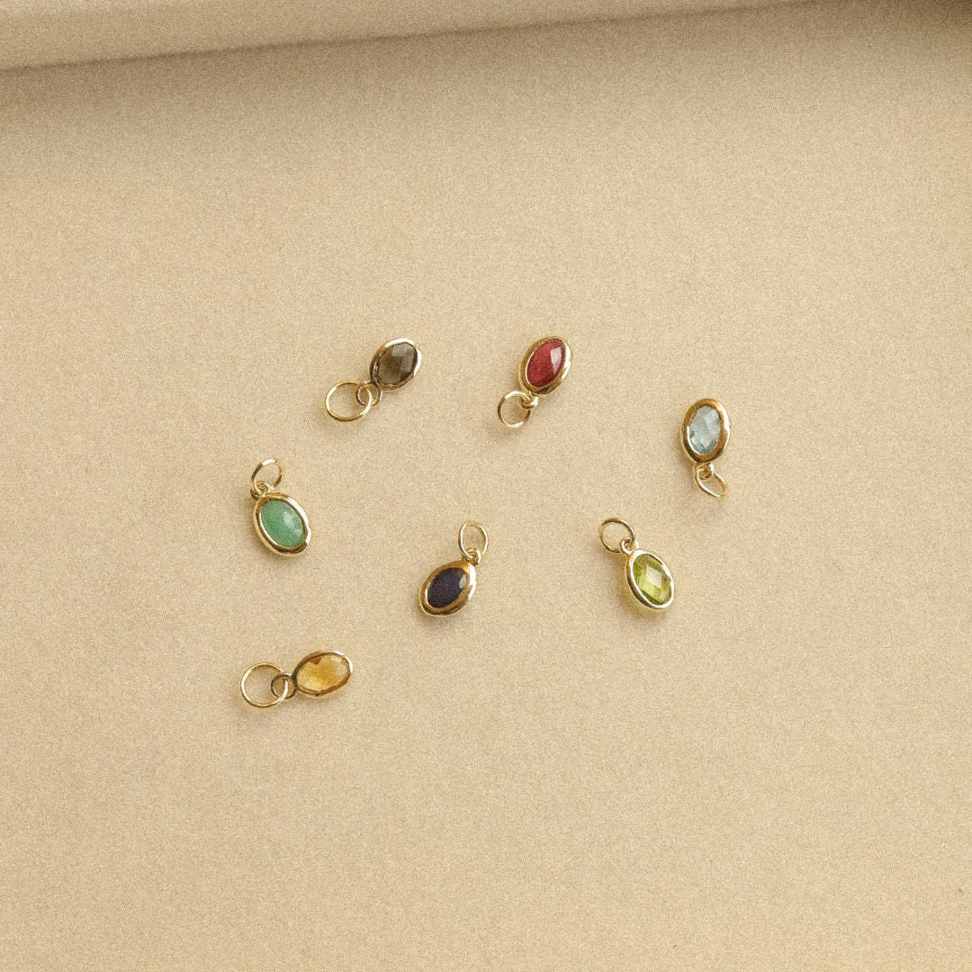 14K gouden birthstone hangers met diverse edelstenen, zoals aquamarijn, robijn en citrien.