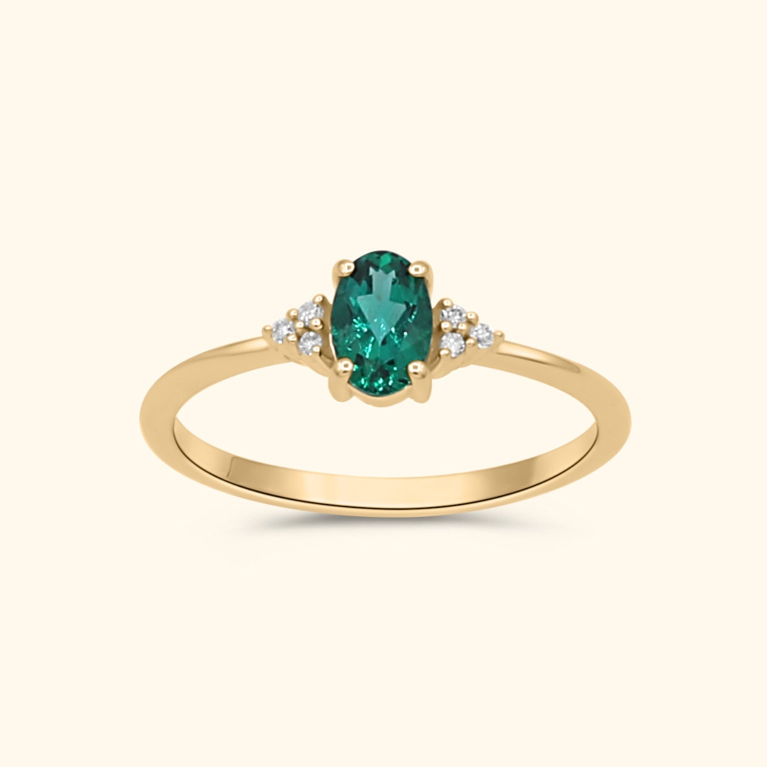 9 karaat gouden ring met een ovale lab grown smaragd en diamanten aan weerszijden.