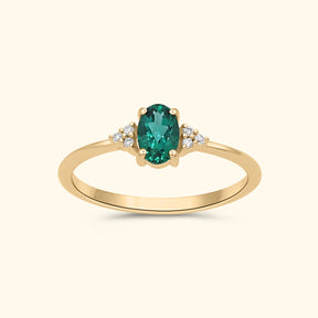 9 karaat gouden ring met een ovale lab grown smaragd en diamanten aan weerszijden.