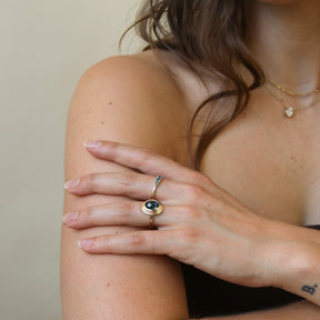 Model draagt de Florence London Blue Topaz Ring van 9 karaat goud met een ovale London Blue Topaz in een bezelzetting.