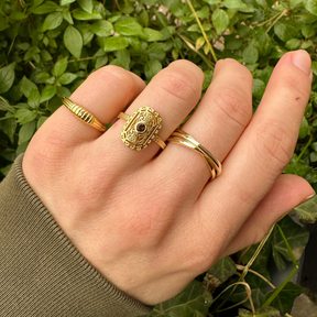 Hand met meerdere gold plated ringen in verschillende stijlen, perfect voor een stijlvolle ring stack.