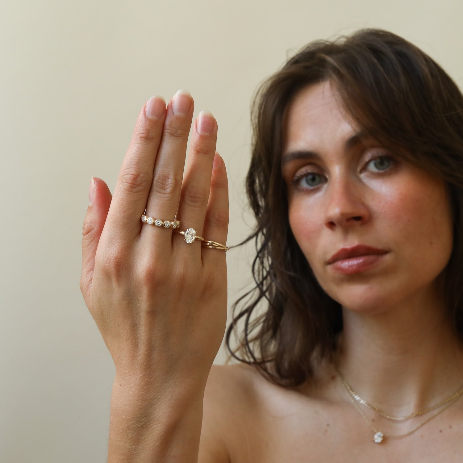 Hailey 1 ct Oval Hidden Halo Diamond Engagement Ring in 14K goud, gedragen op de hand van een model.