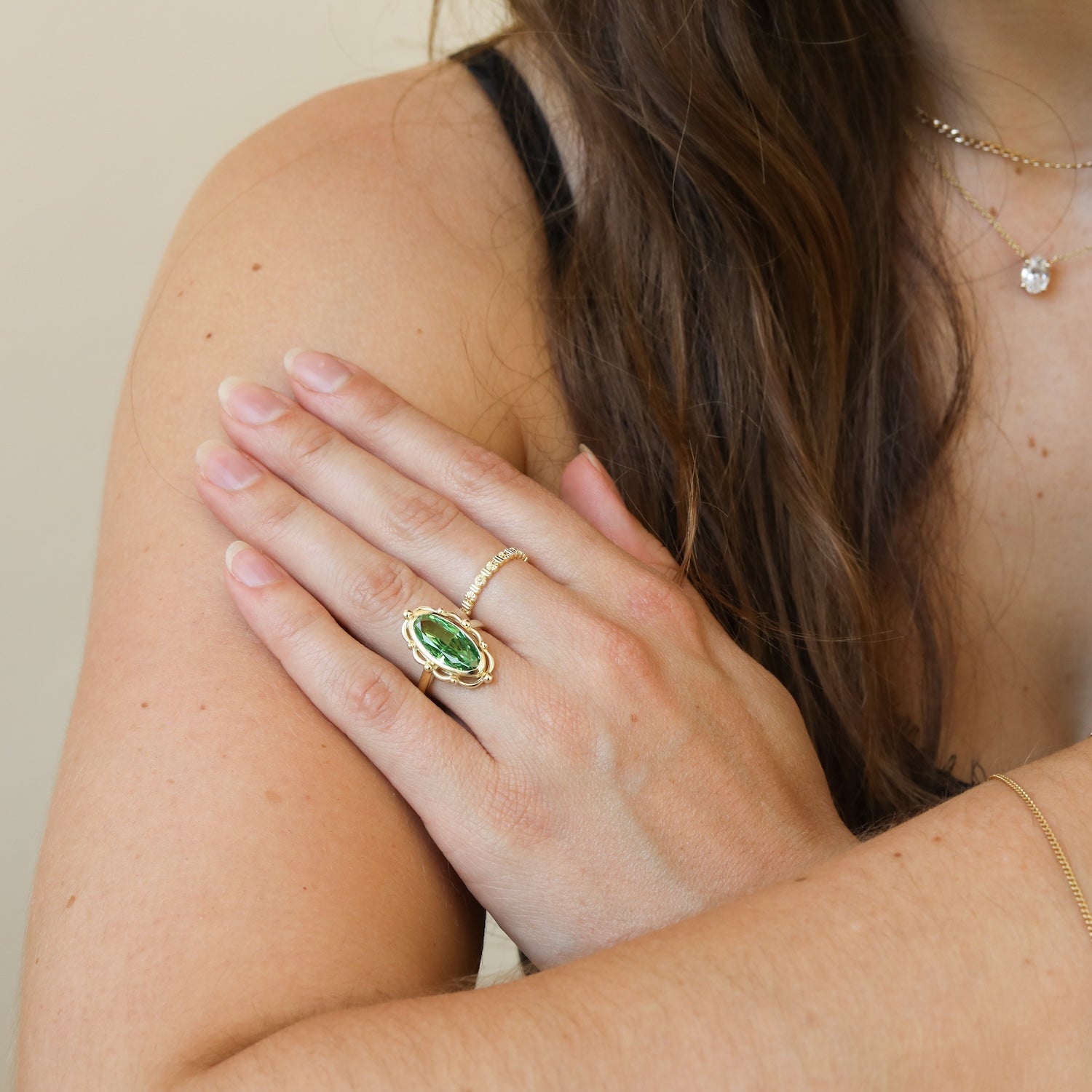 Model draagt de Jane Vintage Green Ring met een groene steen in een vintage ontwerp, gold plated.